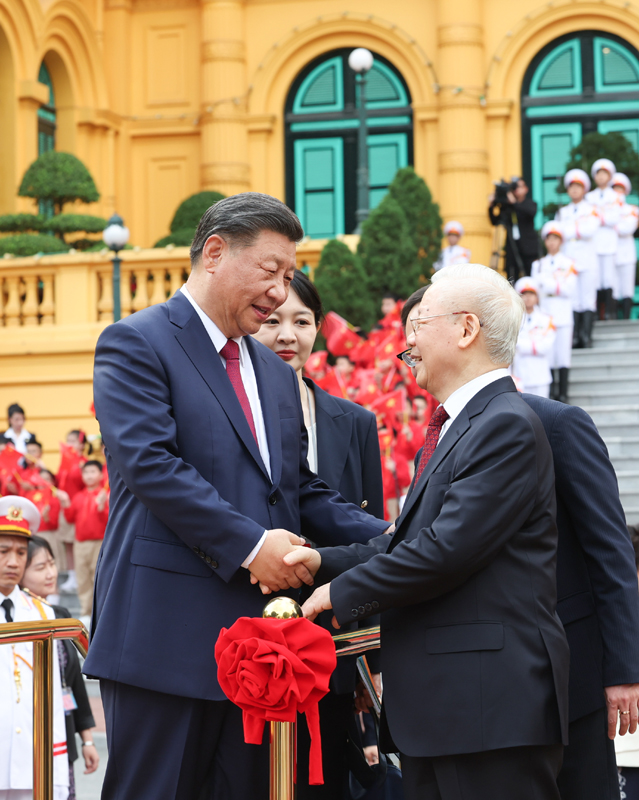 当地时间12月12日下午，刚刚抵达河内的中共中央总书记、国家主席习近平在越共中央驻地同越共中央总书记阮富仲举行会谈。这是阮富仲在主席府广场为习近平举行隆重欢迎仪式。